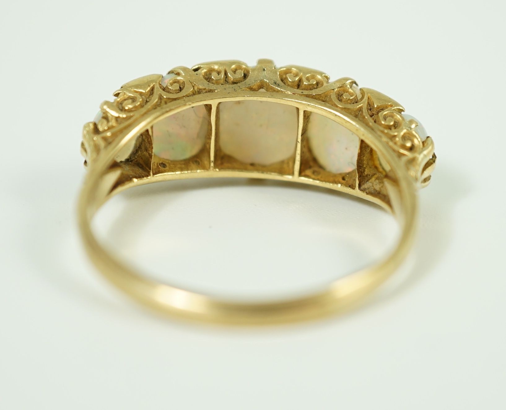 An 18ct gold and graduated five stone opal half hoop ring, with diamond chip spacers
